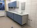 Stół laboratoryjny przyścienny ze stanowiskiem do mycia dwukomorowym, ociekaczem kołkowym typu jeż przyściennym, szafki wiszące